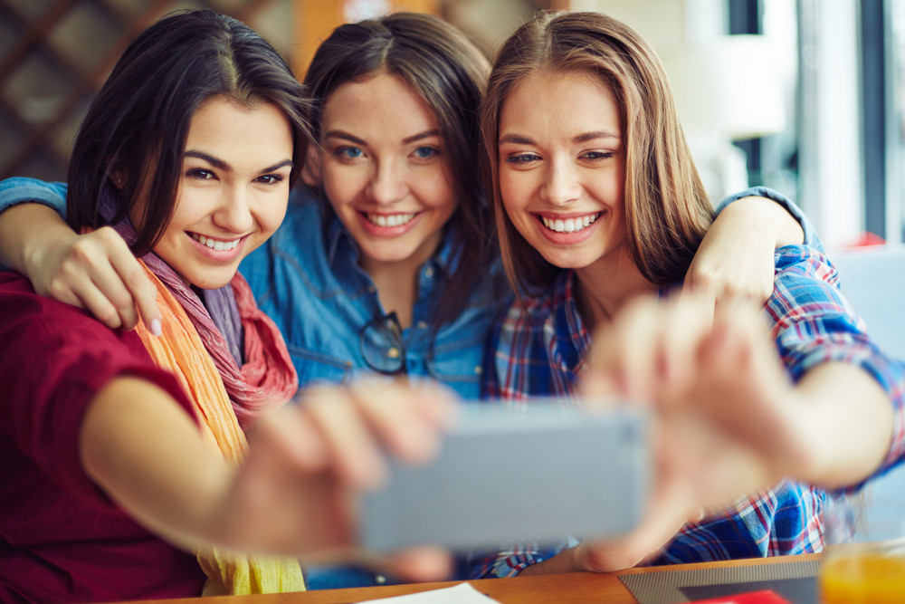 Friendly girls making selfie Royalty-Free Stock Image - Storyblocks