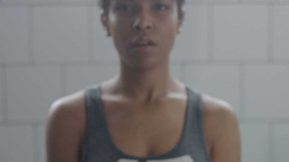 black woman portrait during weight training closeup with foucus on hand with weight moving to a camera Portrait out of focus