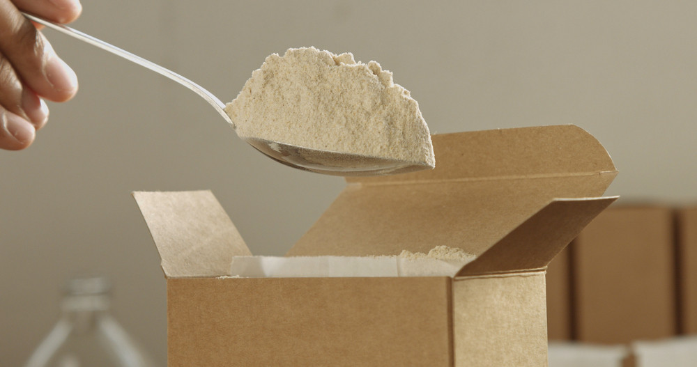 closeup of a spoon takes a flour from box and takes it out