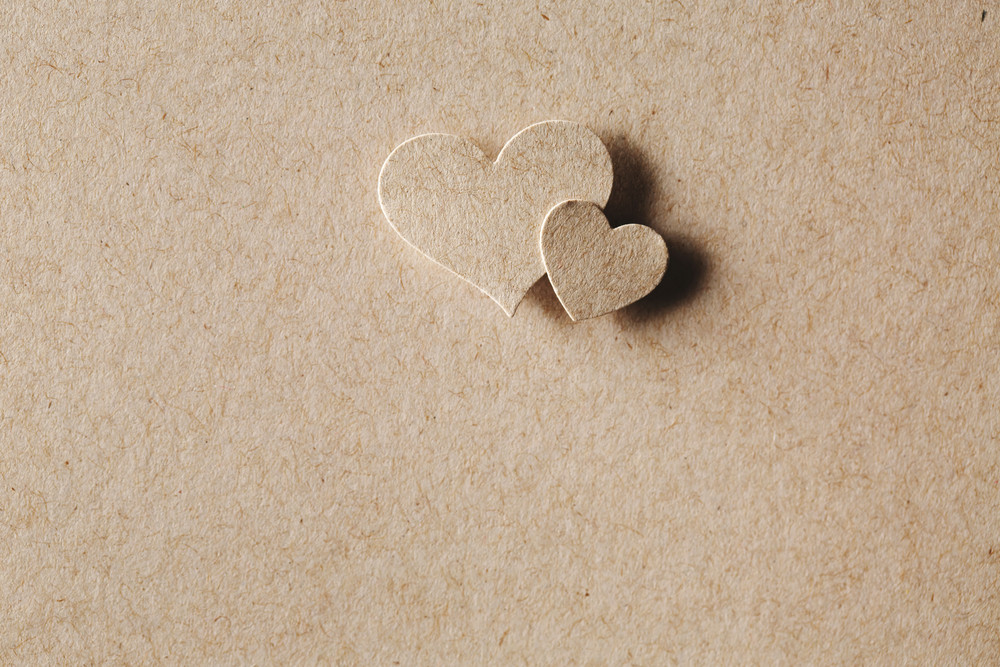 Handmade paper cut hearts on erthy colored paper background