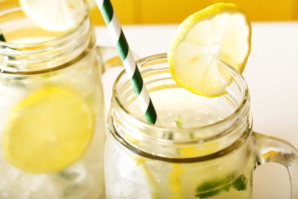 Homemade lemonade in mason jars with big green paper straw