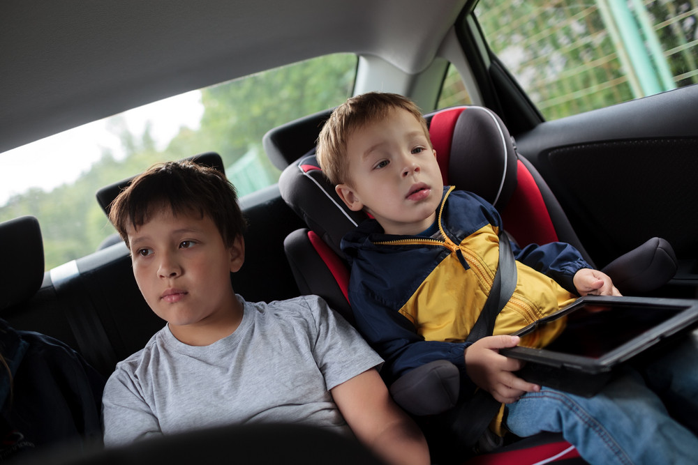 Children sitting in the car and looking at road