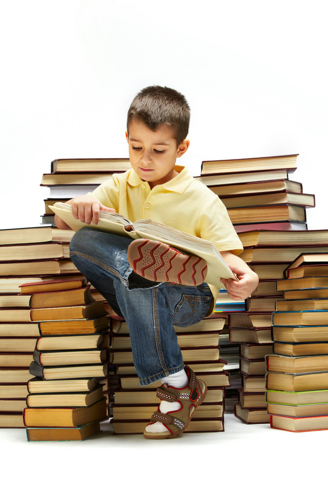 Photo Of Young Boy Reading A Book While Sitting On Books Royalty-Free ...