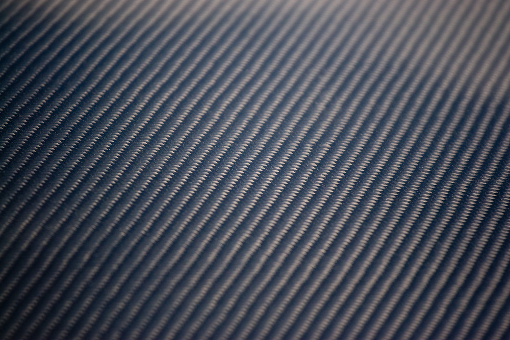 A closeup of real carbon fiber material. This makes an excellent texture or background. Shallow depth of field.