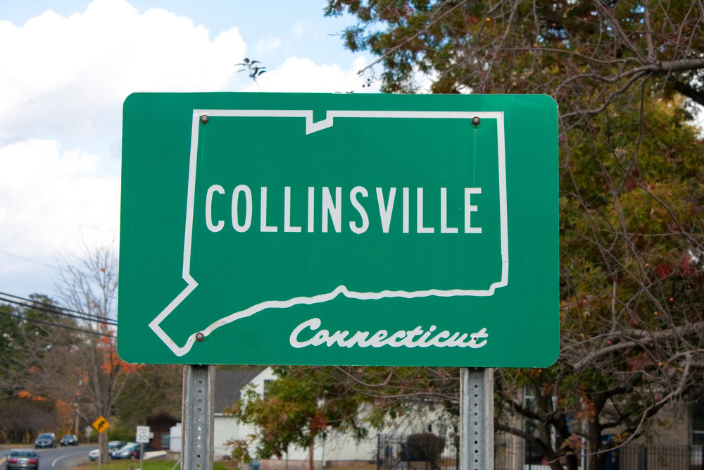 A green public city street sign in Collinsville with the outline of the state of Connecticut in white.