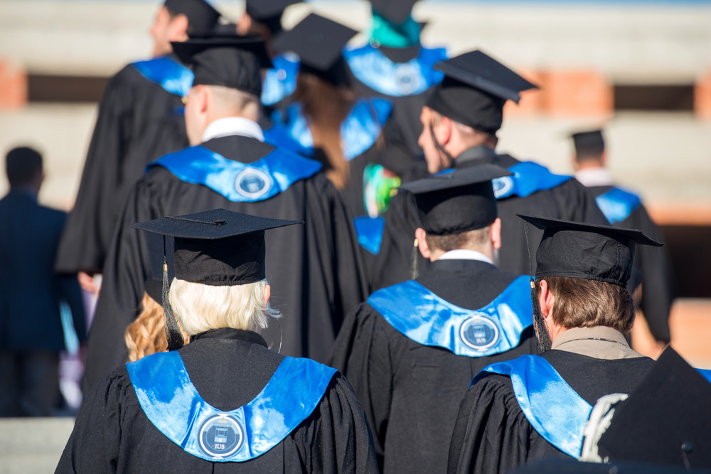 A group of graduates with graduation hats from behind