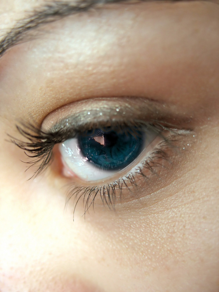 A macro shot of a pretty woman\'s blue eye and lashes - shallow depth of field.