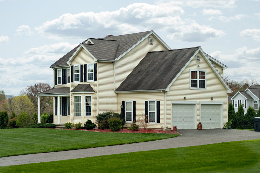 A modern colonial style residential suburban home with a small porch ...