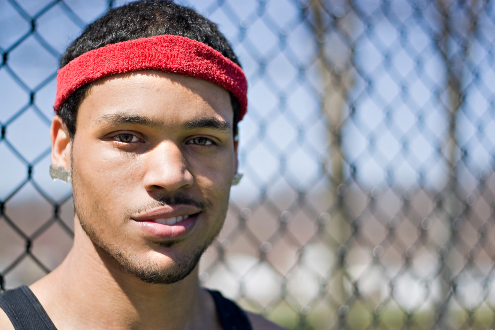 A portrait of a young basketball player at the basketball court in the park.