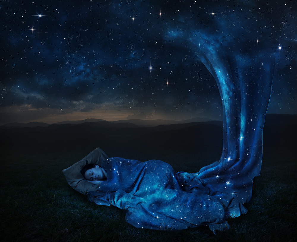 A woman sleeps under a blanket made of stars