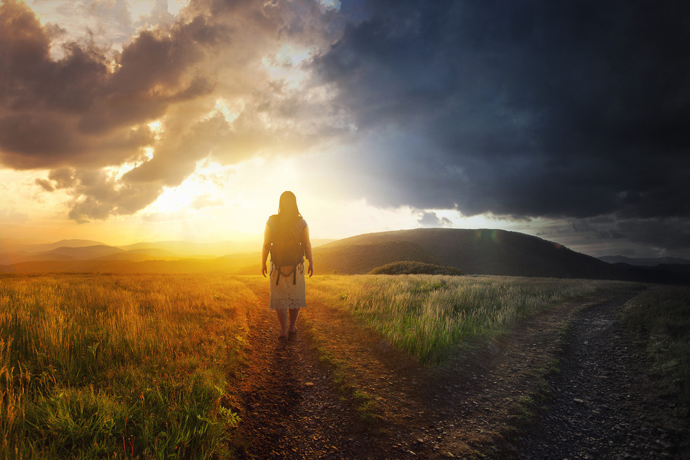 A woman walks down a path towards light. Royalty-Free Stock Image ...