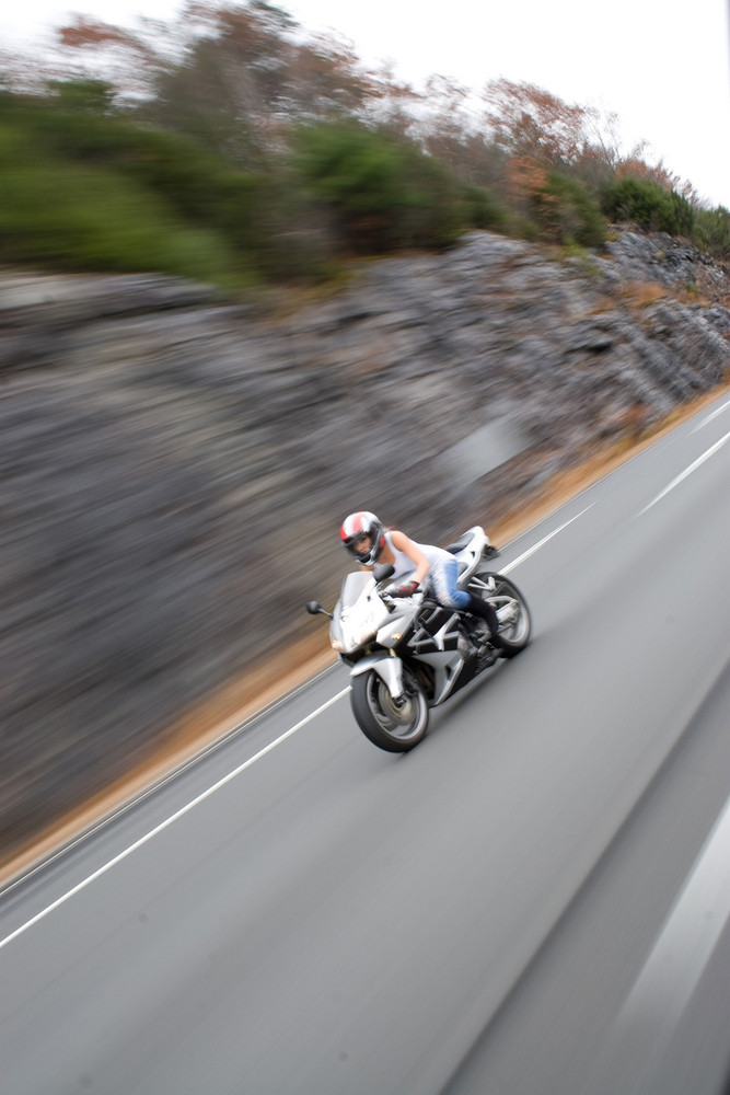 Abstract motion blur of a woman driving a fast motorcycle at highway speeds.