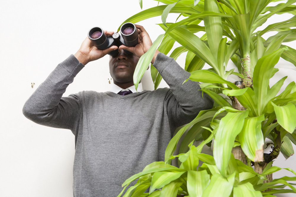 Business person with binoculars in office
