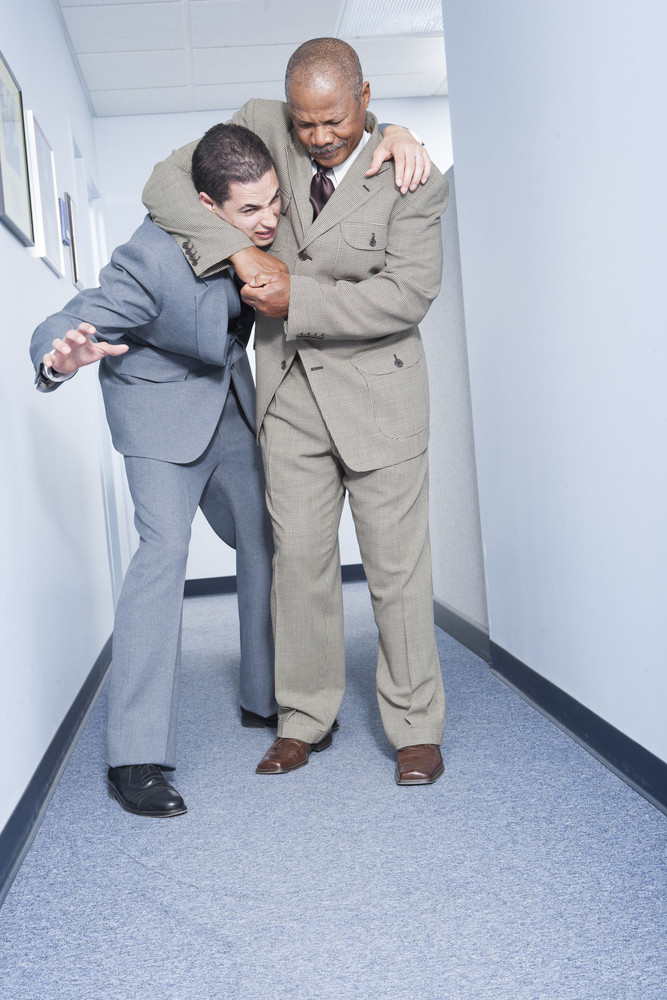 Businessmen fighting in office