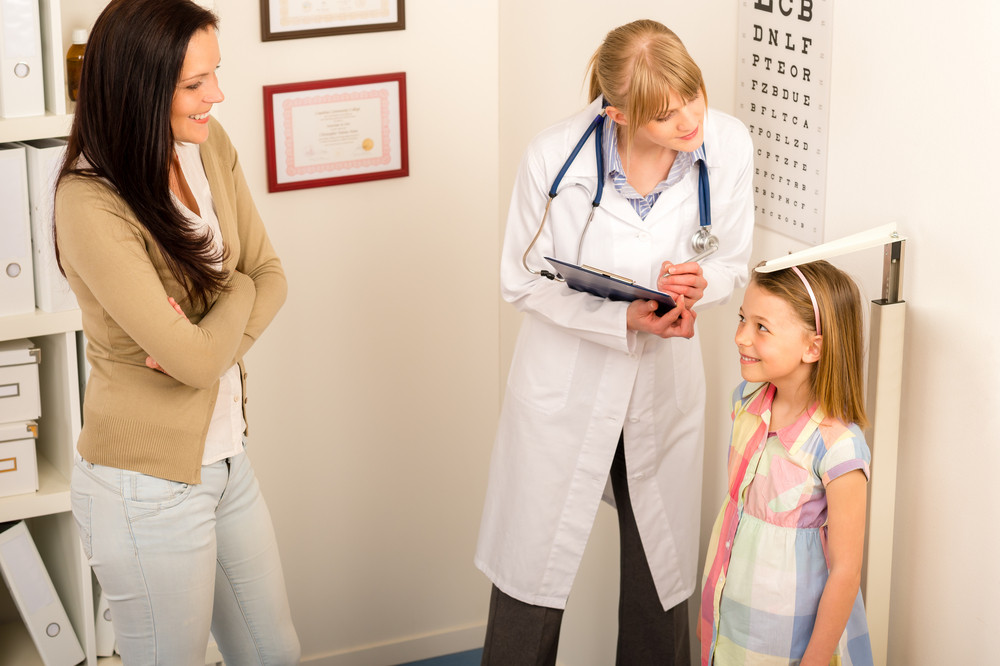 Medical examination at pediatrist girl measure height and weight
