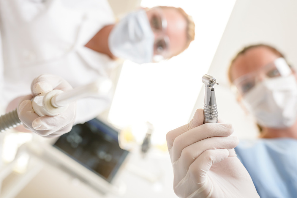 Female dentist focus on drill from patient point of view RoyaltyFree