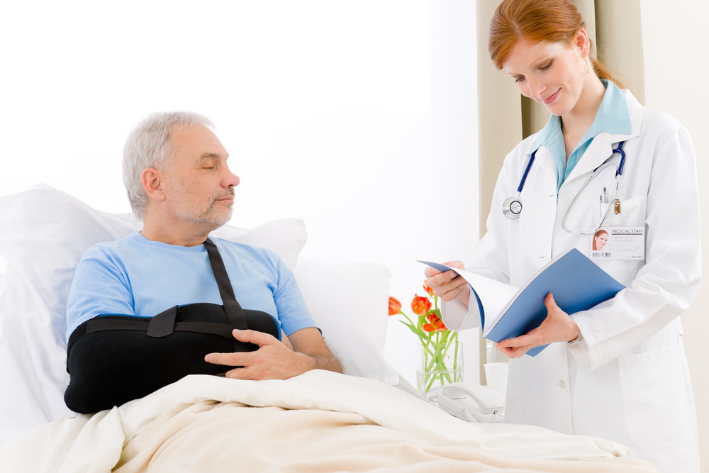 Hospital female doctor examine senior patient with broken arm Royalty