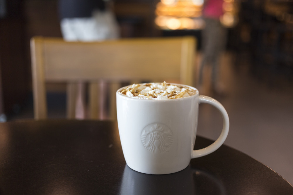 CHIANG MAI, THAILAND - OCTOBER 02, 2014: Starbucks coffee caramel latte white mug in Starbucks Cafe Chiang Mai Thailand. Starbucks is the largest coffeehouse company in the world.