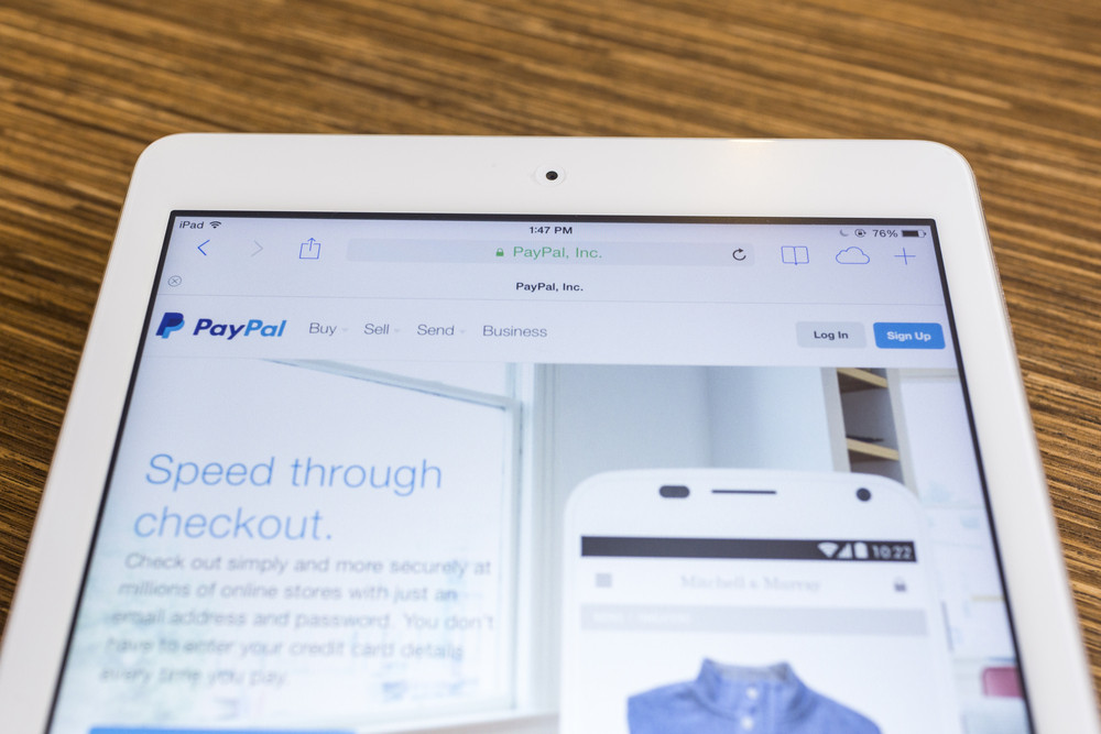CHIANG MAI, THAILAND - SEPTEMBER 17, 2014: Paypal website displayed on Apple iPad Air tablet screen wood background. Established in 1999, PayPal allows payments and money transfers to be made through the Internet.