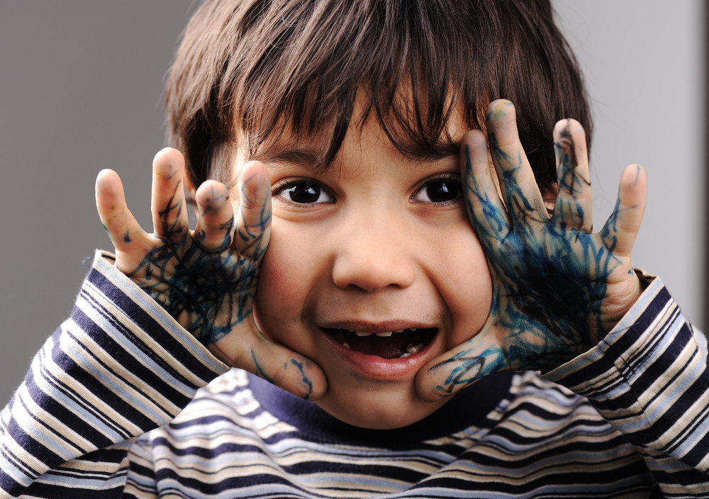 Child with messy hands, green color