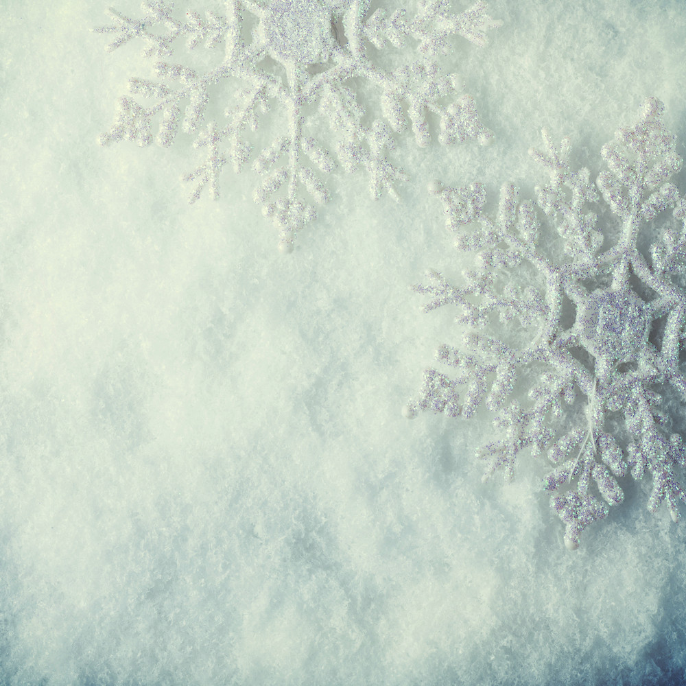 Two beautiful sparkling vintage snowflakes on a white frost snow ...