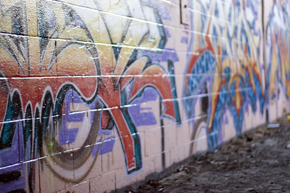 Colorful graffiti spray painted on a brick wall - makes a great background or backdrop. Shallow depth of field.