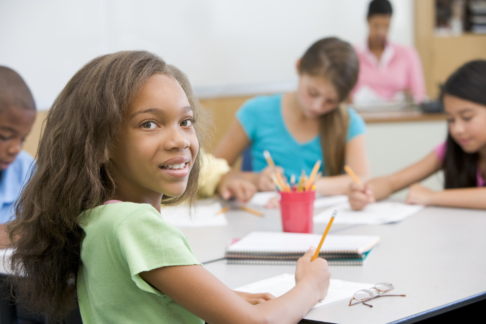 Elementary School Pupil Working At Desk Royalty Free Stock Image