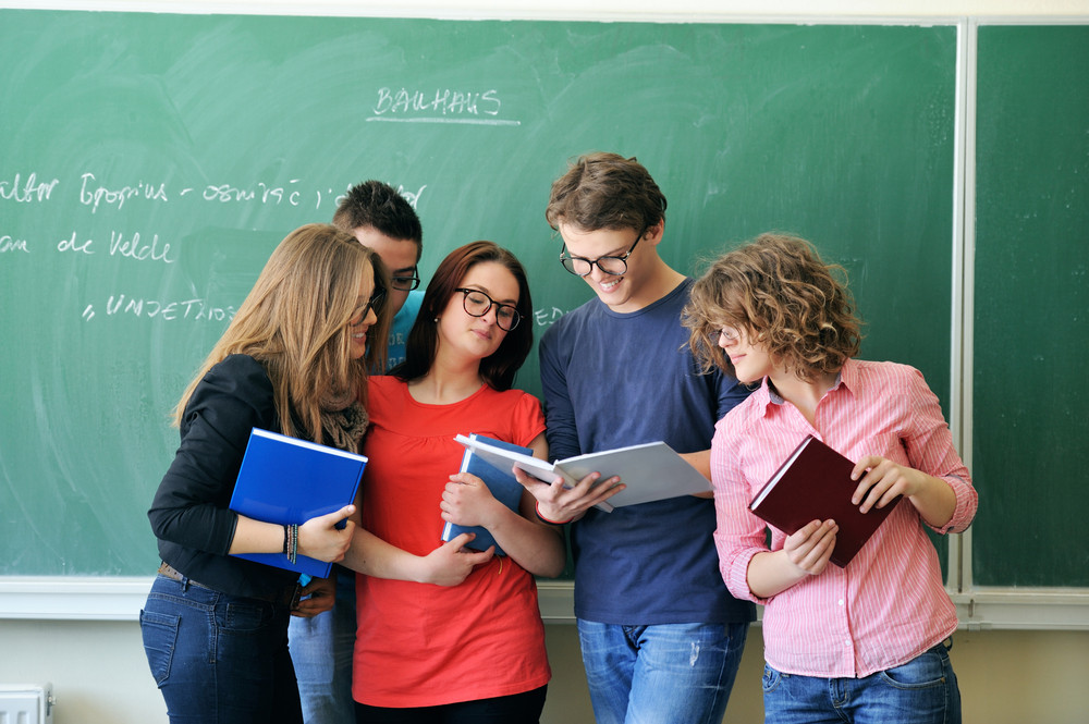Five young people with glasses studying together