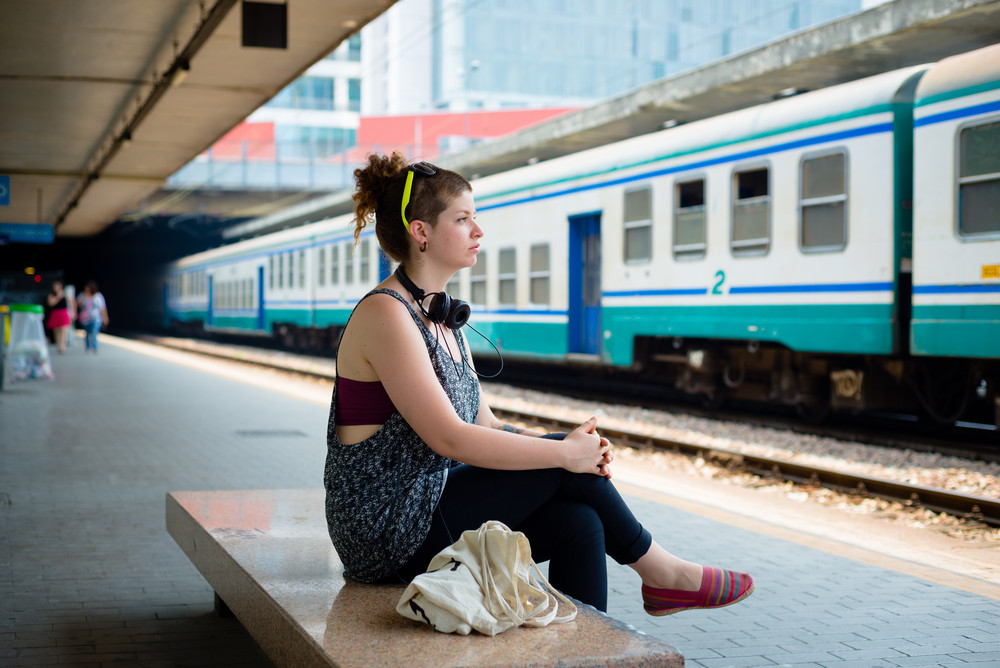 beautiful stylish modern young woman waiting train at the station ...