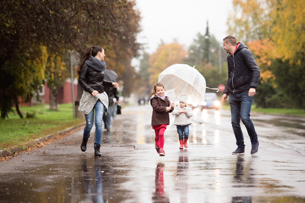 Beautiful Young Family With Two Daughters Under The Umbrellas