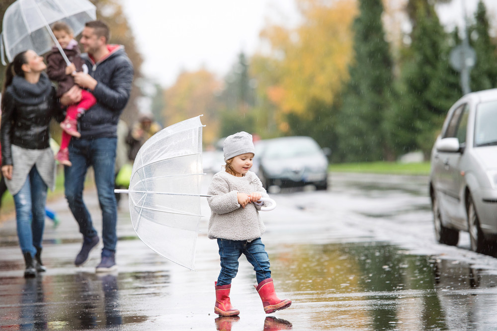 Beautiful Young Family With Two Daughters Under The Umbrellas