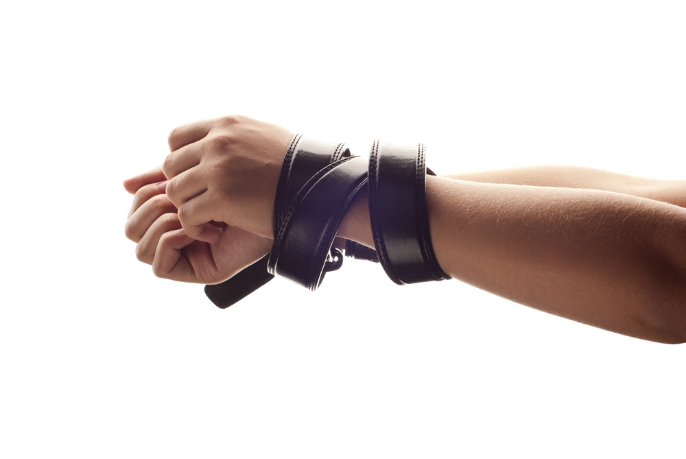 Hands of woman are tied up by belt. RoyaltyFree Stock