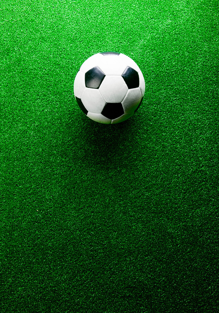 Soccer ball against artificial turf, studio shot on green background ...