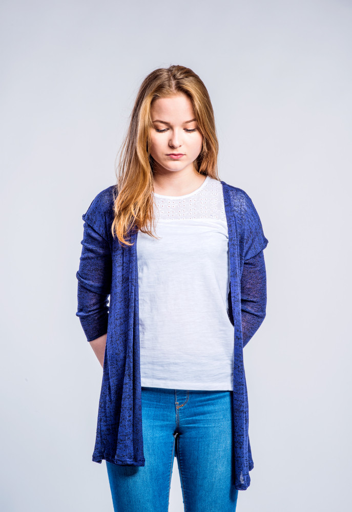 Teenage girl in jeans and long blue sweater, young woman, studio ...