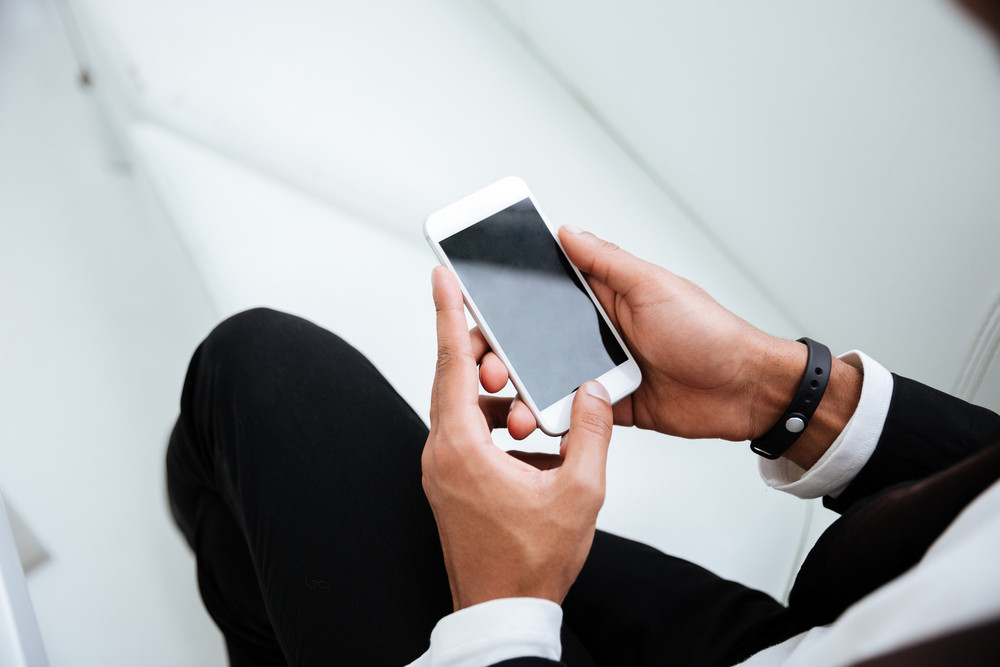 Top view of african business man in black suit holding phone in hands ...