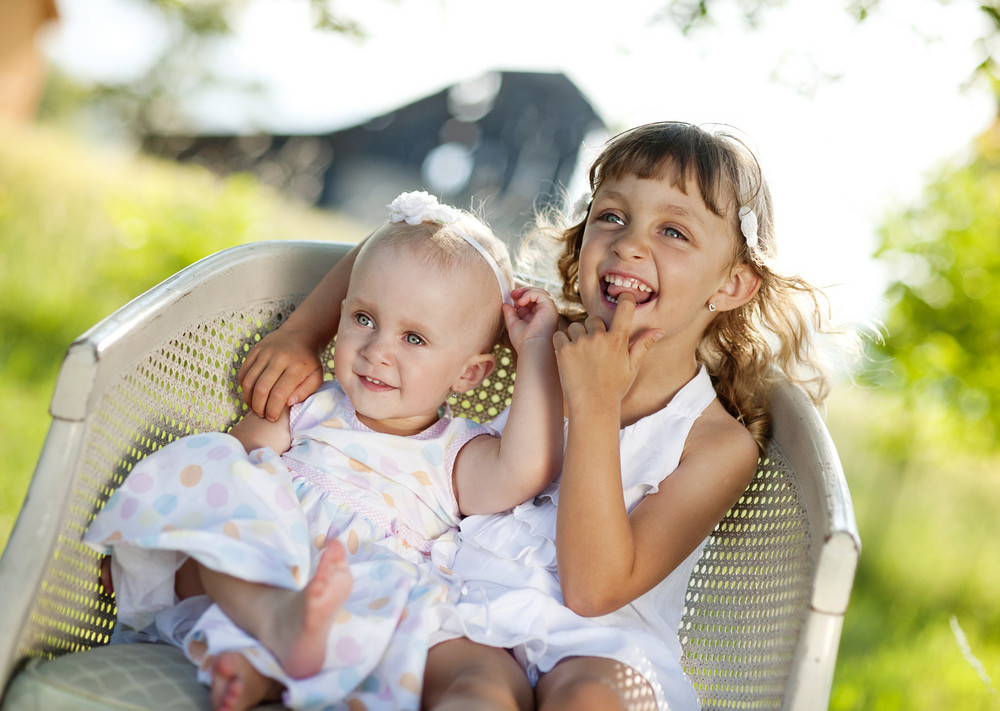 Two Cute Little Sisters Laughing And Playing In Green Sunny Park Royalty Free Stock Image