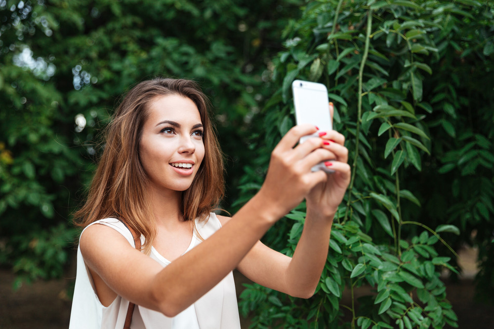 Young Beautiful Brunette Woman Making Selfie With Smartphone Outdoors