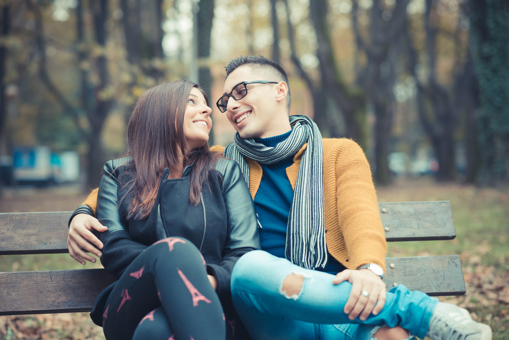 young couple in the park during autumn season outdoor - lovers valentine