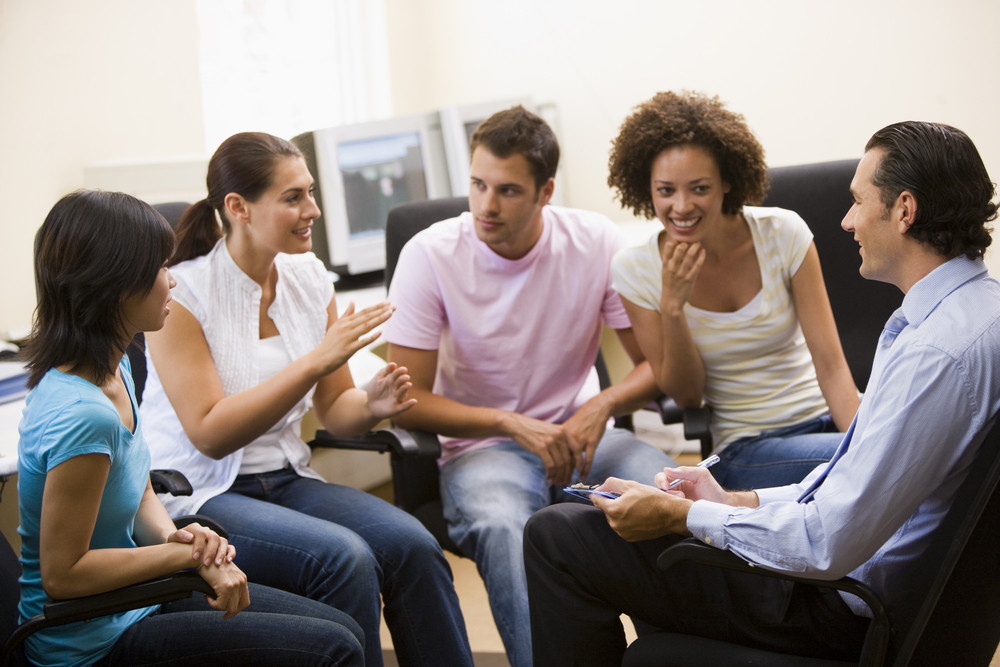 Man giving lecture to four people in computer room Royalty-Free Stock ...