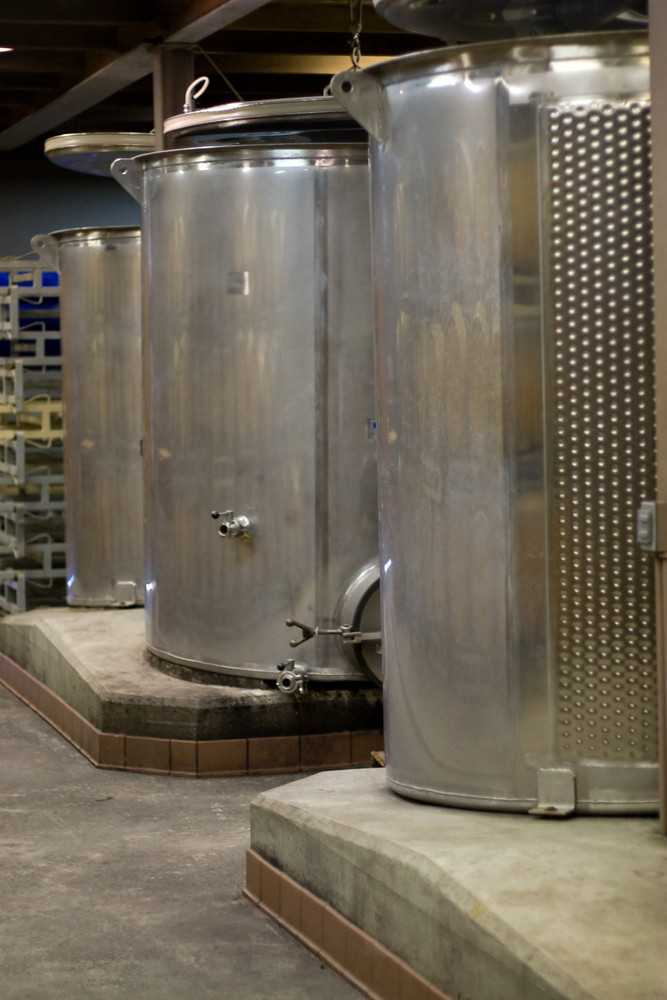 Modern aluminum barrels where grape juice is aged into wine located in a vineyard cellar.