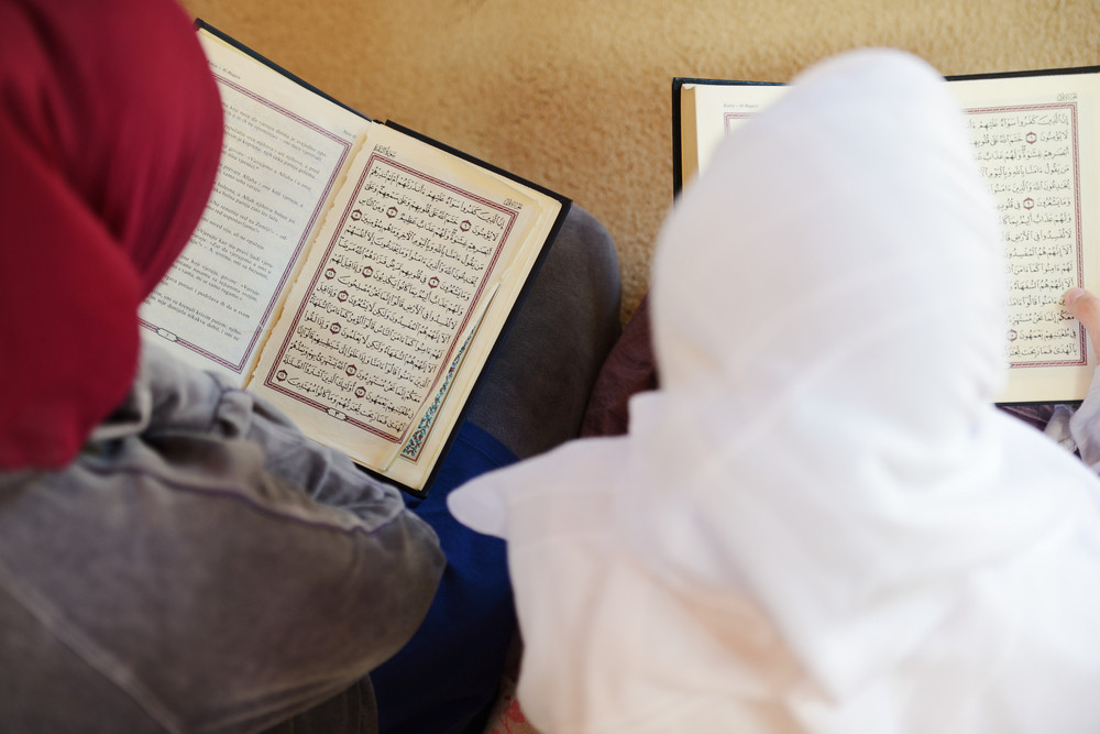 Muslim and Arabic girls reading Koran together in group
