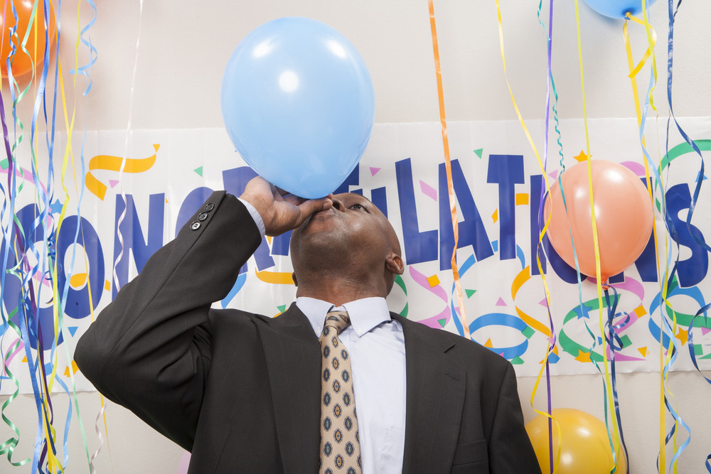Office staff blowing up balloons