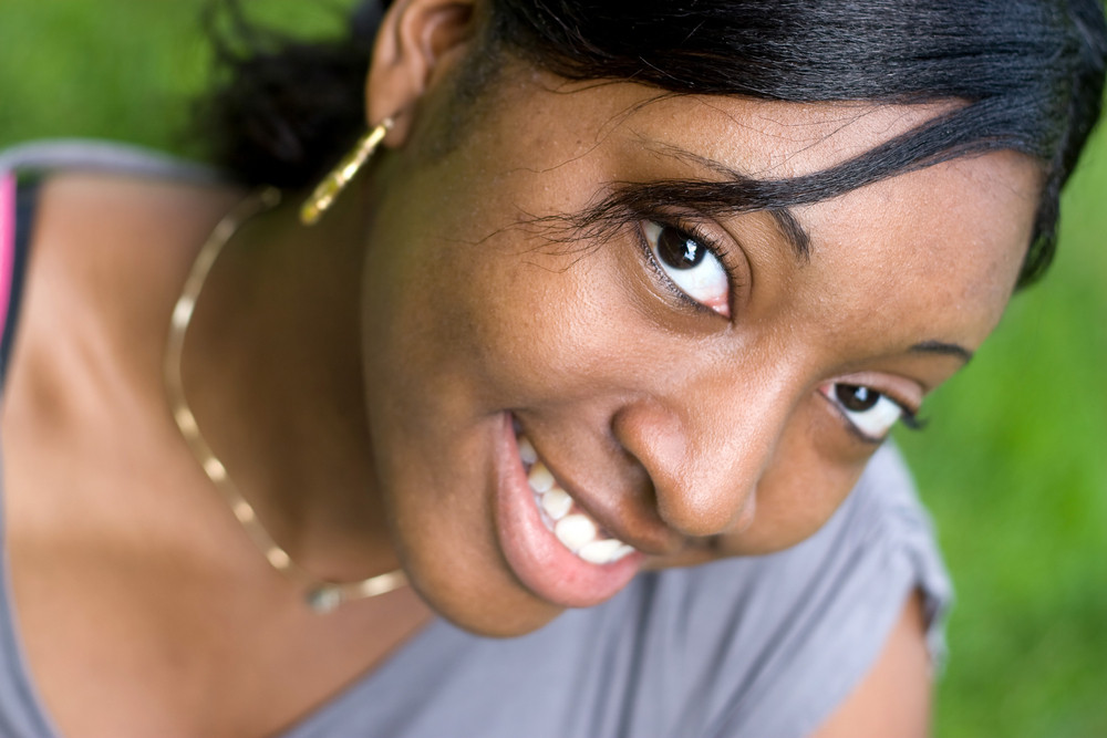 Portrait of a young Jamaican woman with a natural smile. Shallow depth of field.