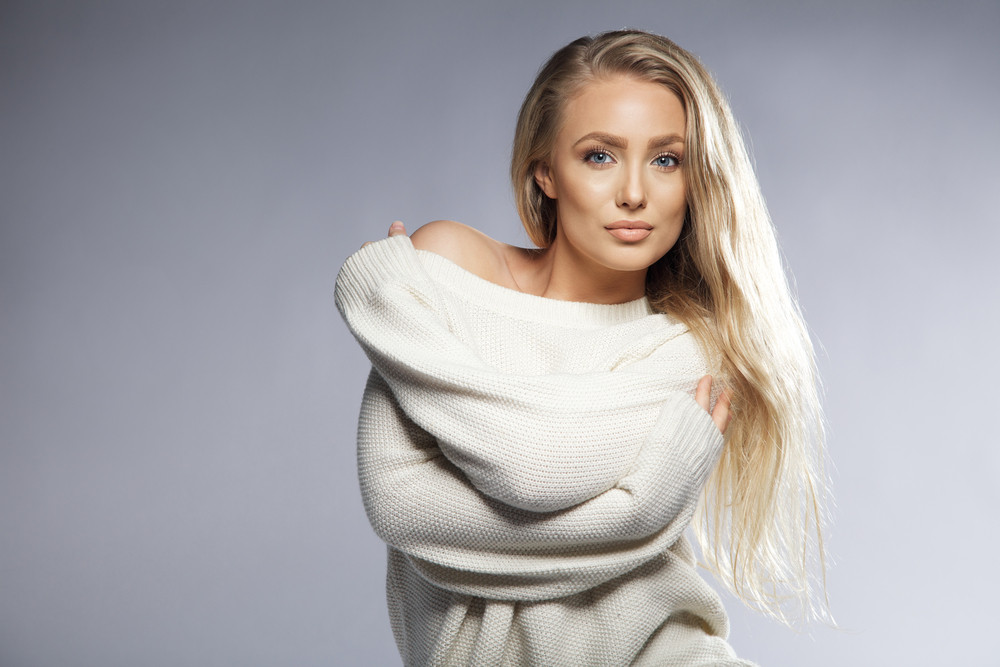 Portrait Of Sensual Young Woman Wearing Oversized Sweater Looking At 