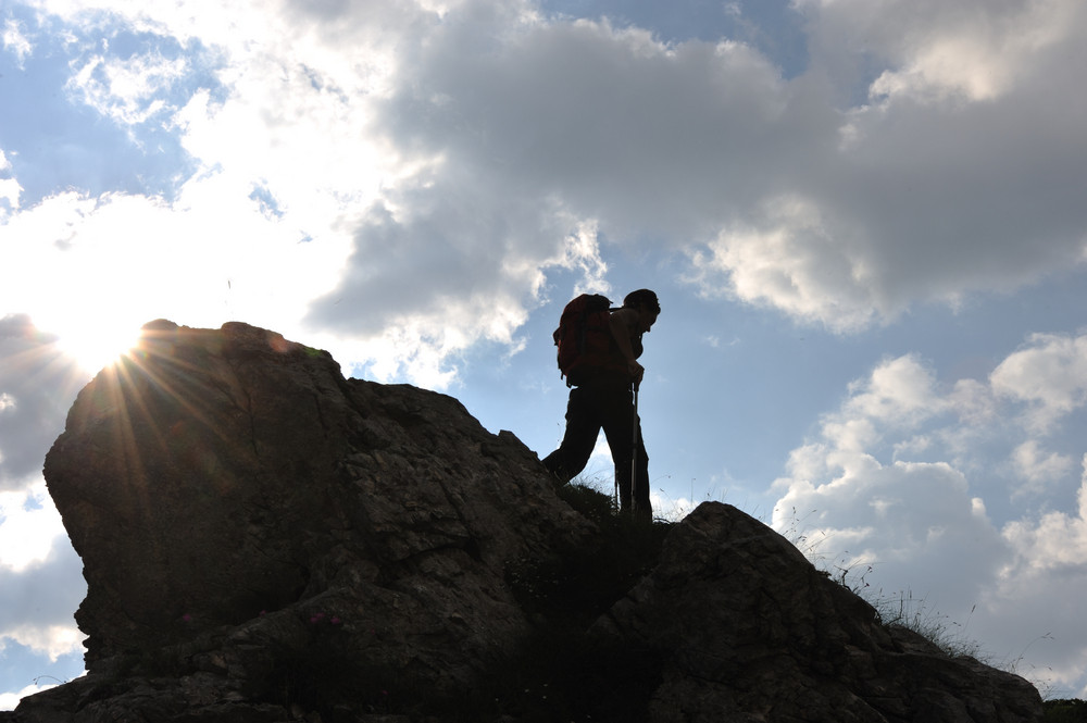 Silhouette of a woman during and adventage climbing and mountain walking