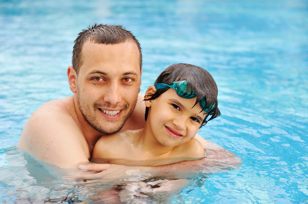 Smiling Father And Son Leaning In The Water Pool Royalty Free Stock