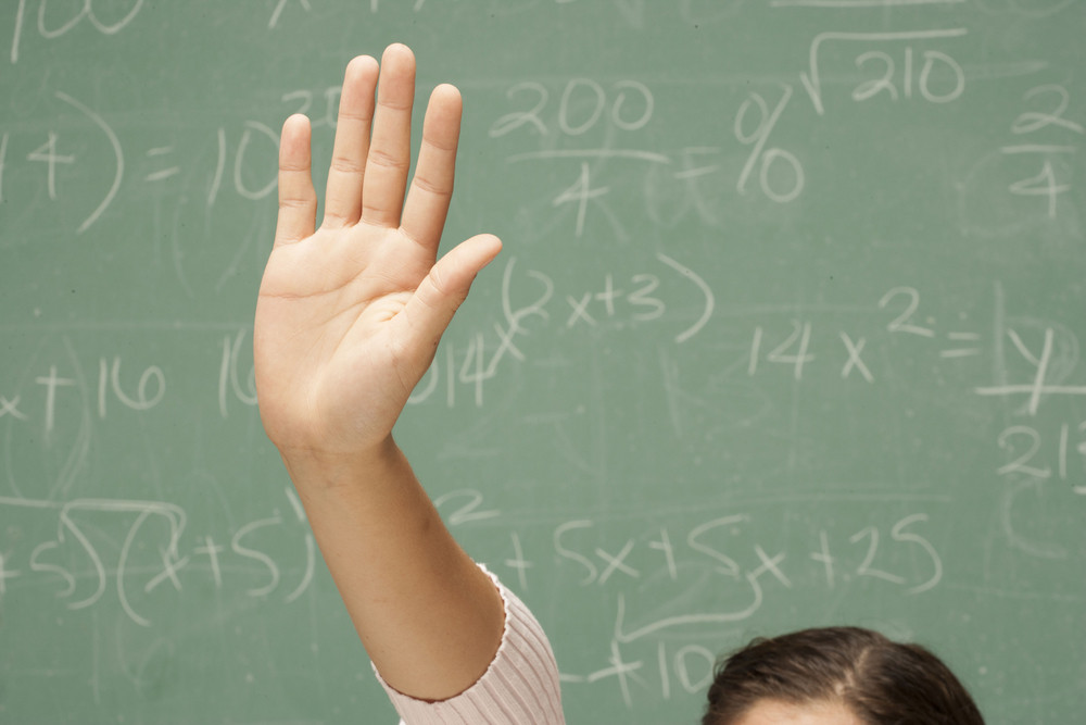 Student\'s hand raised in classroom