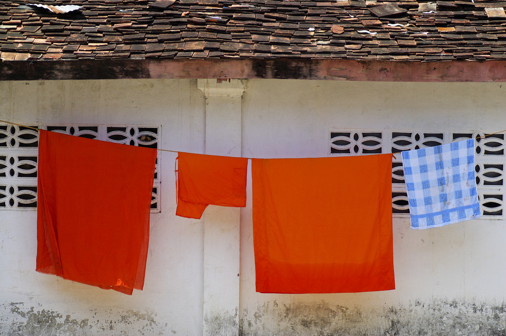 Thai Buddhist monks\' robes hanging at a temple wall in Laos