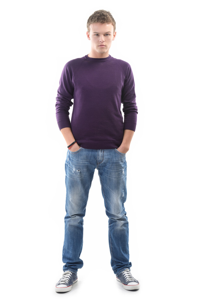 Young Man Posing With His Hands In His Pockets On White Background