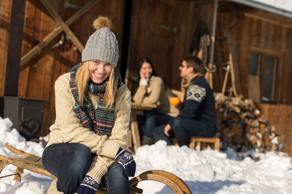 Young woman with friends enjoy weekend break snow winter cottage